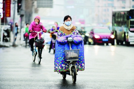 <br>          3月22日，太原亲贤北街与体育路十字路口，行人因降雨再度穿上冬装抵卸冷空气的侵袭。本报记者 董元炜 摄<br><br>        