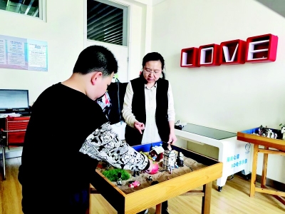 <br>          温静轩和学生进行沙盘游戏互动 本报记者 康乐 摄<br><br>        