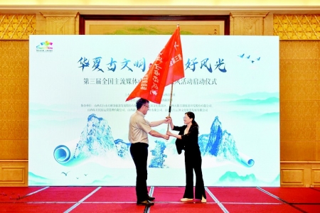           山西省文化和旅游厅副厅长李贵为媒体团代表授旗 图片由山西省文化和旅游厅提供        