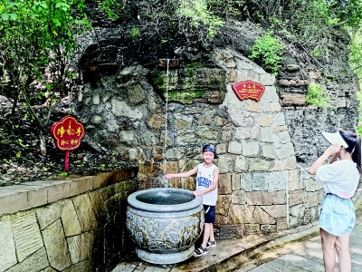 <br>          汩汩泉水吸引游客拍照留念 本报记者 康乐 摄<br><br>        
