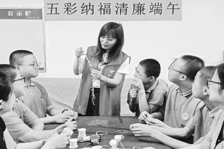           志愿者演示五彩绳编制过程        