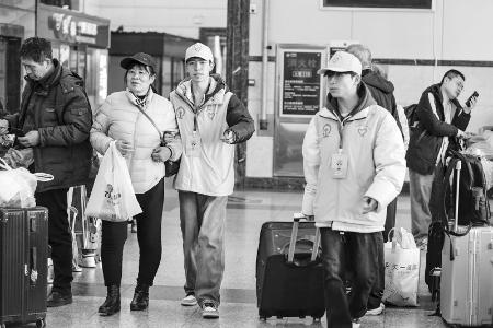           帮助行动不便的旅客推运行李 景永军 摄        