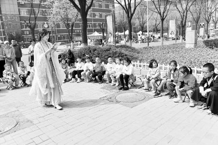           青年学子身着汉服带领孩子们阅读 图片由通讯员提供        