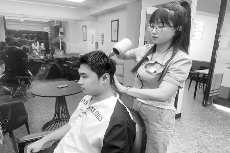           皇恩娟正为一名男士设计发型 见习记者 路诗洁 摄        