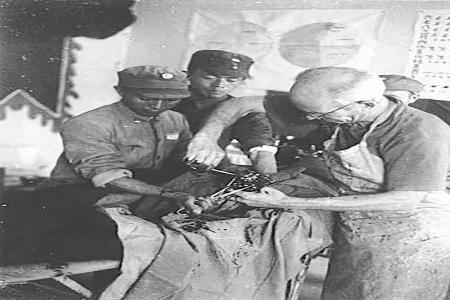 　　在中国人民抗日战争中，许多国际友人来到中国，支援中国人民抗日战争。图为白求恩在五台县松岩口模范病室为八路军伤员做手术。