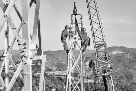               8月22日，国网山西送变电公司员工正在进行流动式起重机组塔施工。张涛 摄        