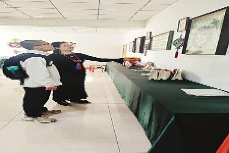 和顺牵绣筑梦团队长白天阳在听传承人张丽娜讲解作品