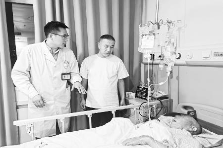 王鑫（左一）细心问诊住院患者
